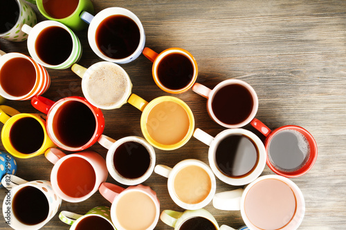 Many cups of coffee on wooden table, top view