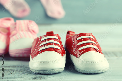 Cute toddler shoes and socks on wooden background