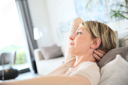Free Download Middle-aged woman relaxing in sofa at home - GFXLoad