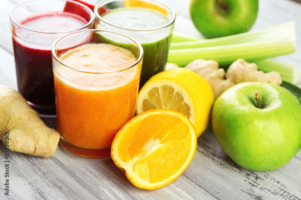 Assortment of healthy fresh juices on wooden table background Assortment of healthy fresh juices on wooden table background