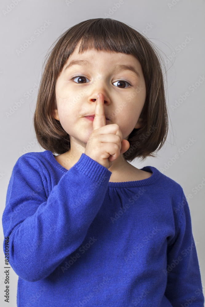 preschool girl wanting to keep silent with her finger on lips preschool girl wanting to keep silent with her finger on lips