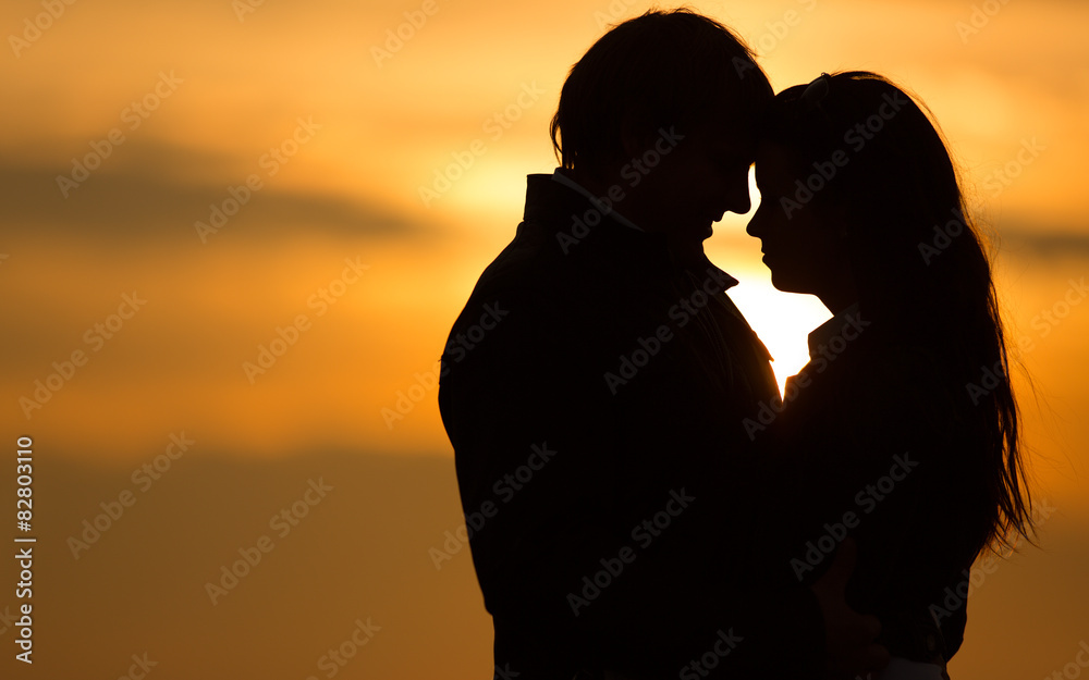 Silhouettes of romantic couple on the beach during sunset