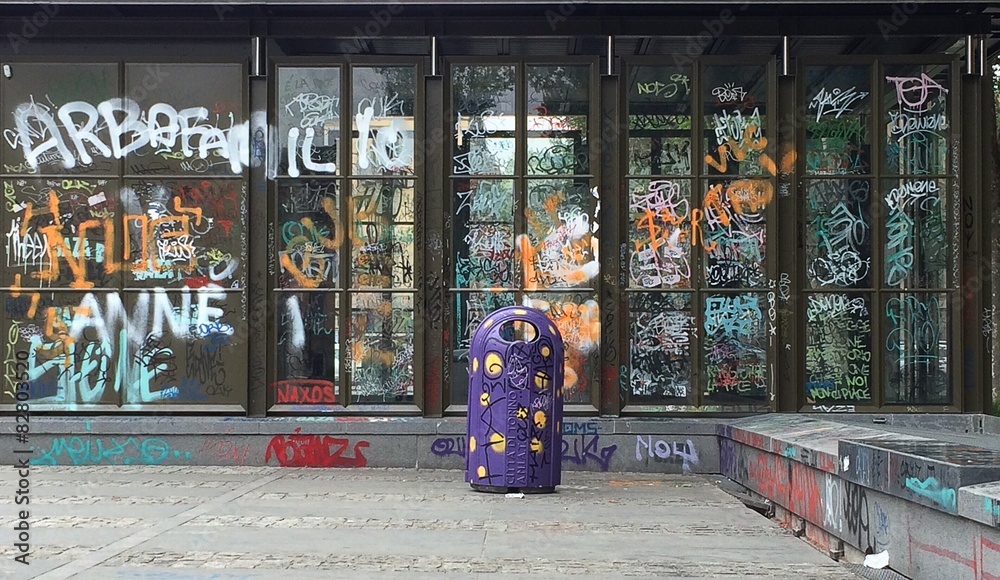 Graffiti su vetrina e cassonetto