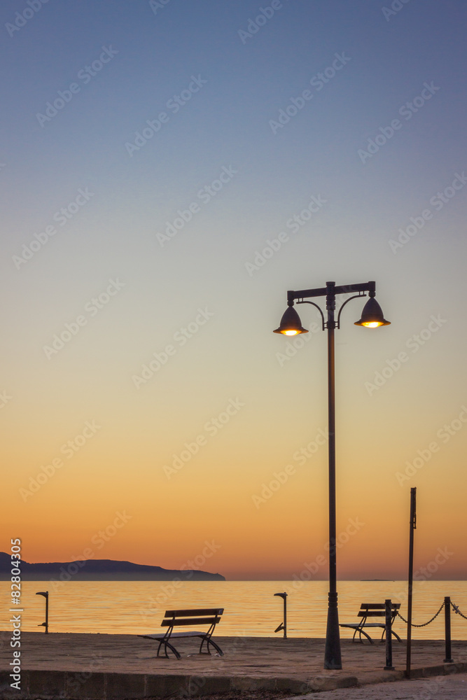 Sea beach benches at sunset