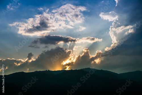 Sunset behind mountain with beautiful sunbeam through the cloud © crazybboy