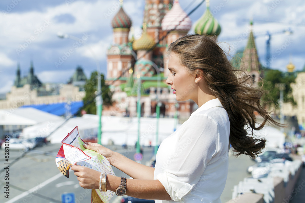 Young beautiful girl holding a tourist map of Moscow, Russia