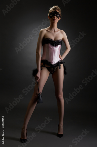 Domineering woman in erotic lingerie with lash