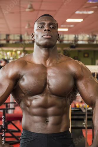 Attractive hunky black male bodybuilder in gym
