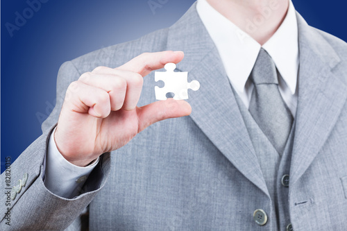 Business man showing blank jigsaw puzzle piece