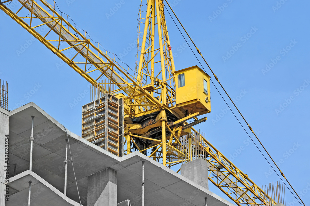 Crane and building construction site against blue sky Crane and building construction site against blue sky
