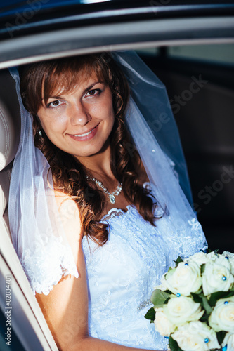 close-up portrait of pretty shy bride in a car window