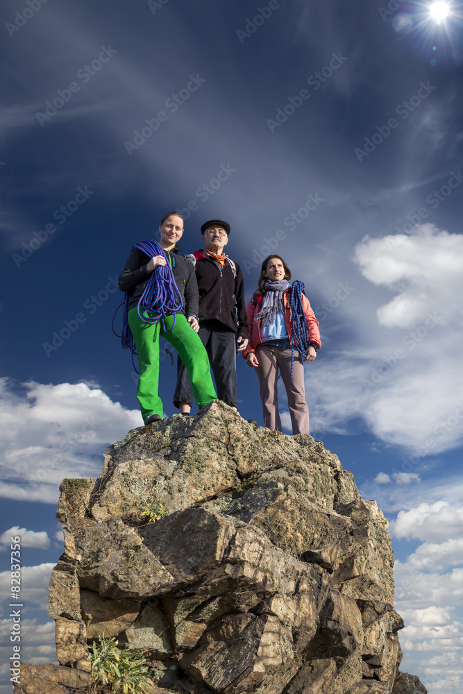Group of climbers stays on the pointed cliff