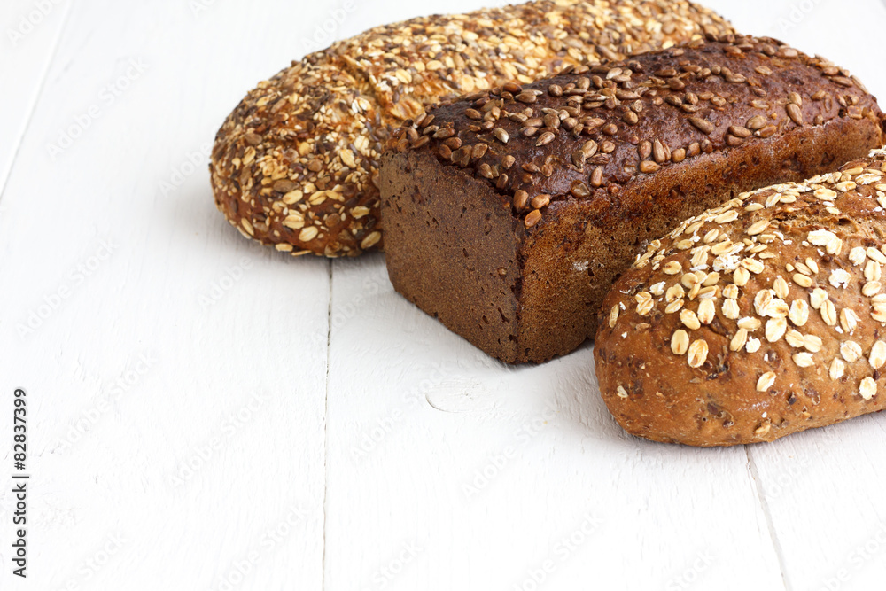 Mixed whole grain health breads on rustic painted wood.