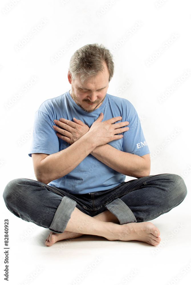 The young man folded his hands in prayer, over white, isolated The young man folded his hands in prayer, over white, isolated