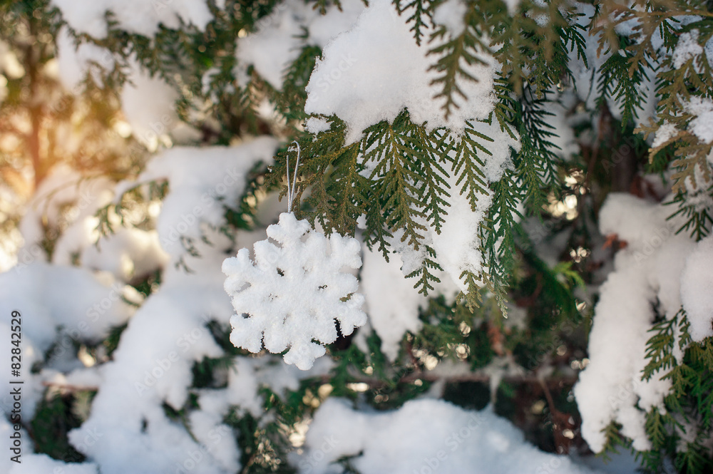 Beautiful Christmas toy on a snow-covered tree in winter Beautiful Christmas toy on a snow-covered tree in winter