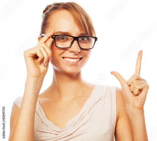 woman wearing glasses pointing up