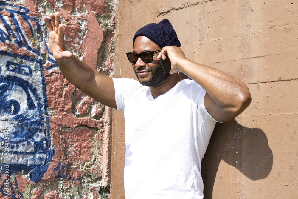 Obraz premium black man talking on mobile phone in the street