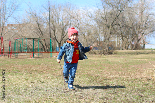 Happy little boy runs outdoors in springtime