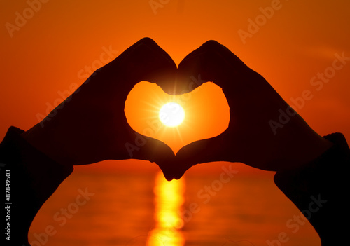 Romantic Heart Shape with hands at sunset