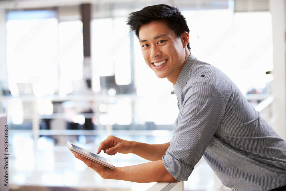 Portrait of young man using tablet in office Portrait of young man using tablet in office