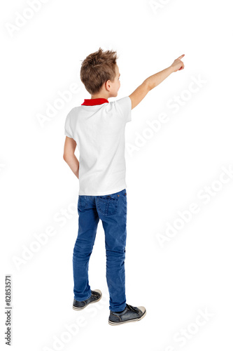 Rear view of a school boy over white background pointing upwards