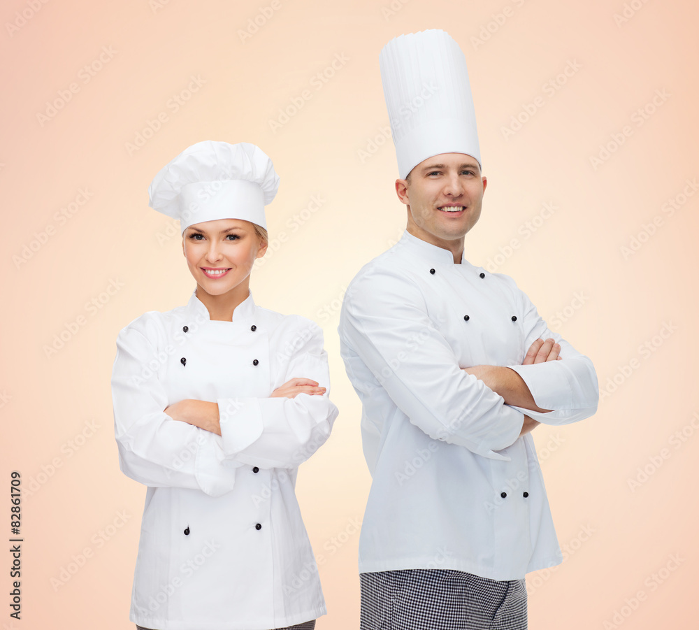 happy chefs or cooks couple over beige background happy chefs or cooks couple over beige background