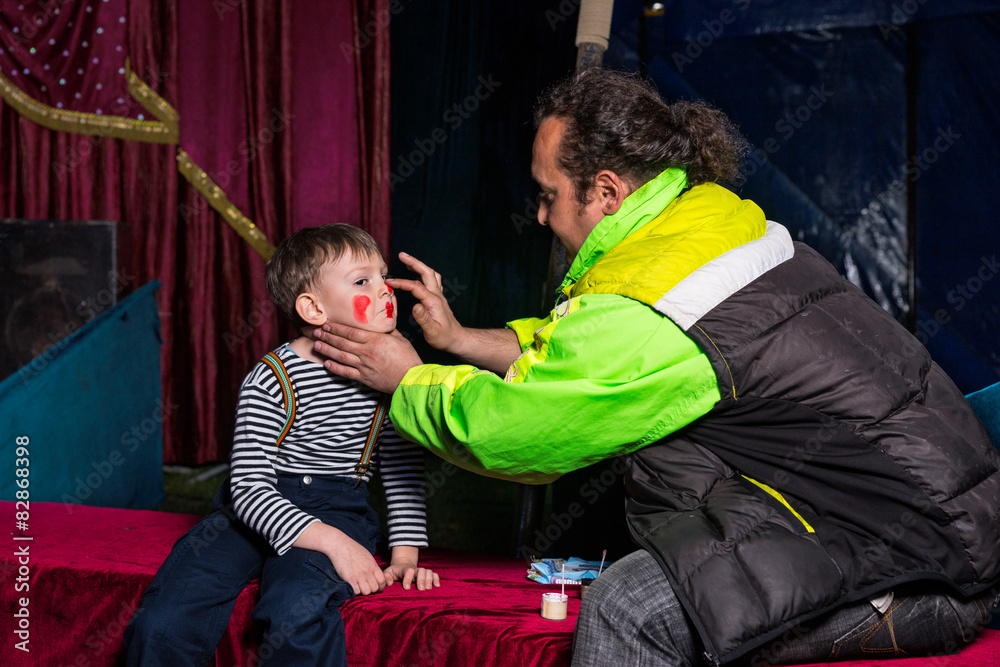 Obraz premium Man Applying Clown Make Up to Boys Face