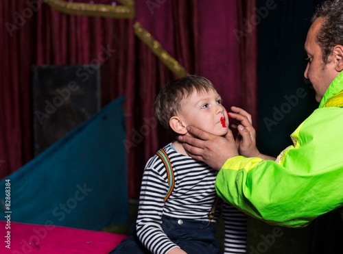 Man Applying Clown Face Make Up on Boy