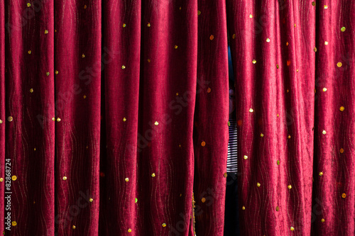 Little boy lurking behind the stage curtains