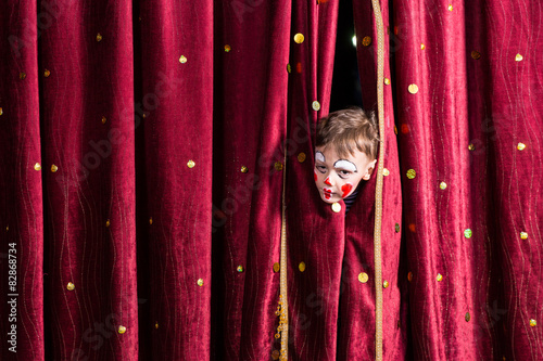 Impatient young actor peeking out from the curtain