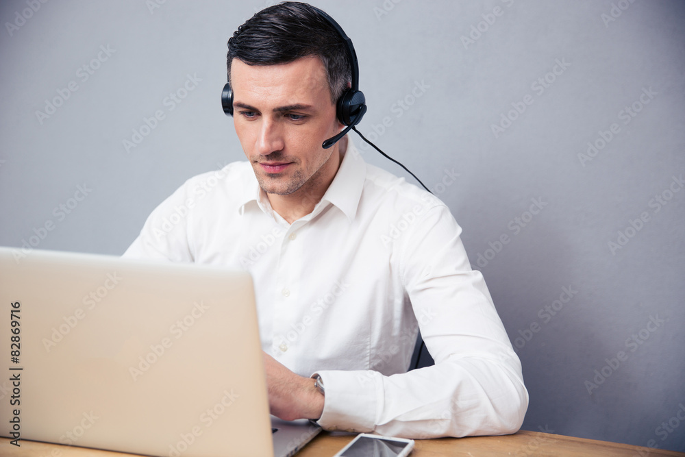 Businessman working on laptop with headphones Businessman working on laptop with headphones