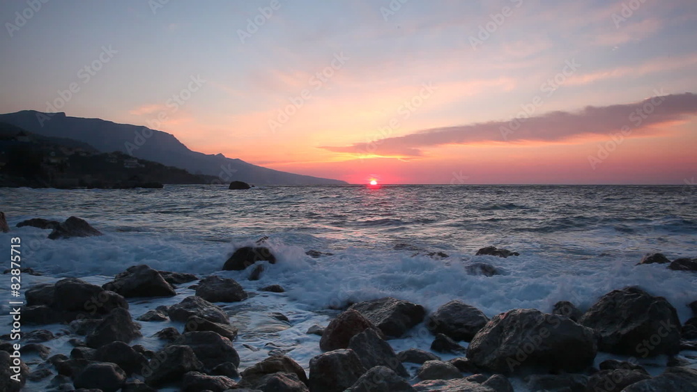 Waves break about stones at sunrise over the sea Waves break about stones at sunrise over the sea