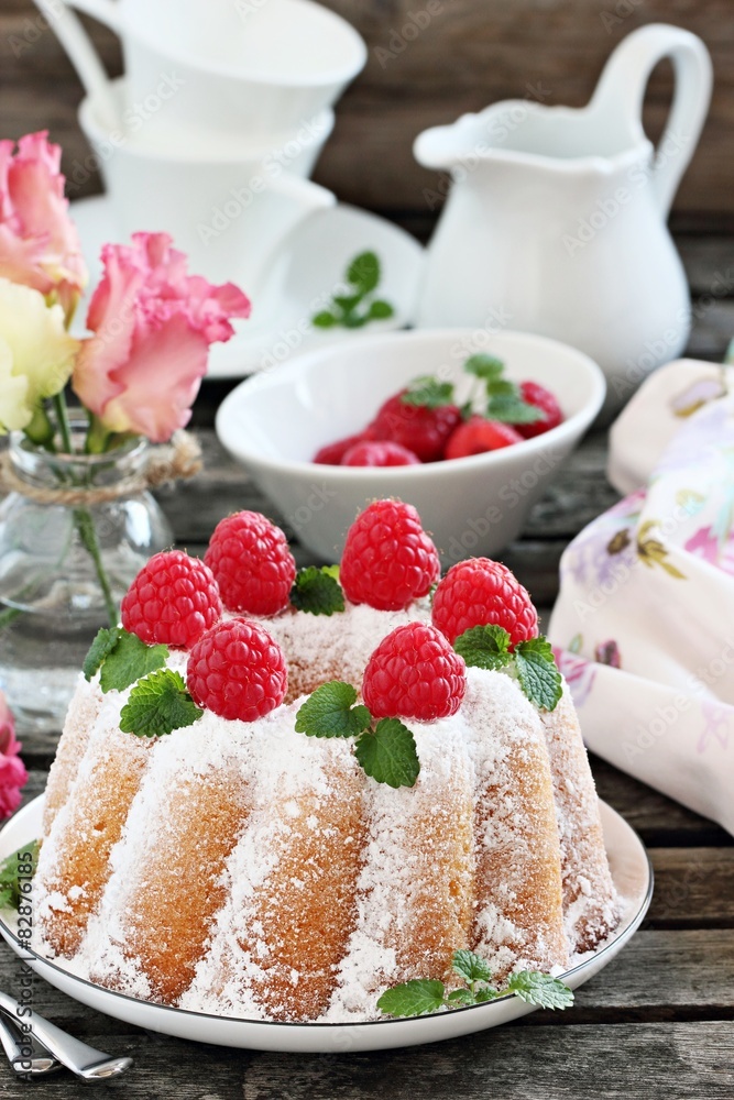 Bundt cake with fresh raspberries on a rustic dark background Bundt cake with fresh raspberries on a rustic dark background