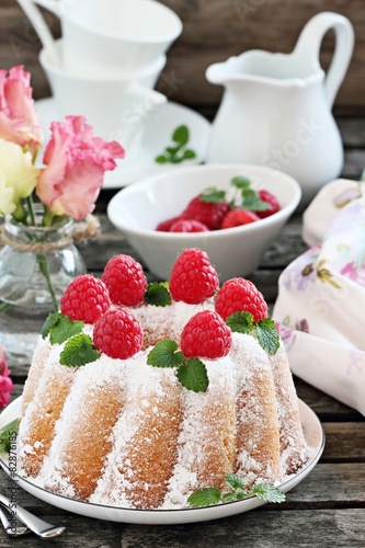  Bundt cake with fresh raspberries on a rustic dark background
