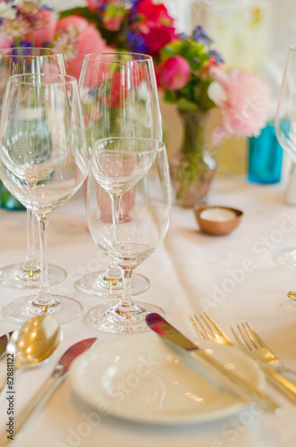 cutlery, wine glasses and flowers on a table at a wedding party