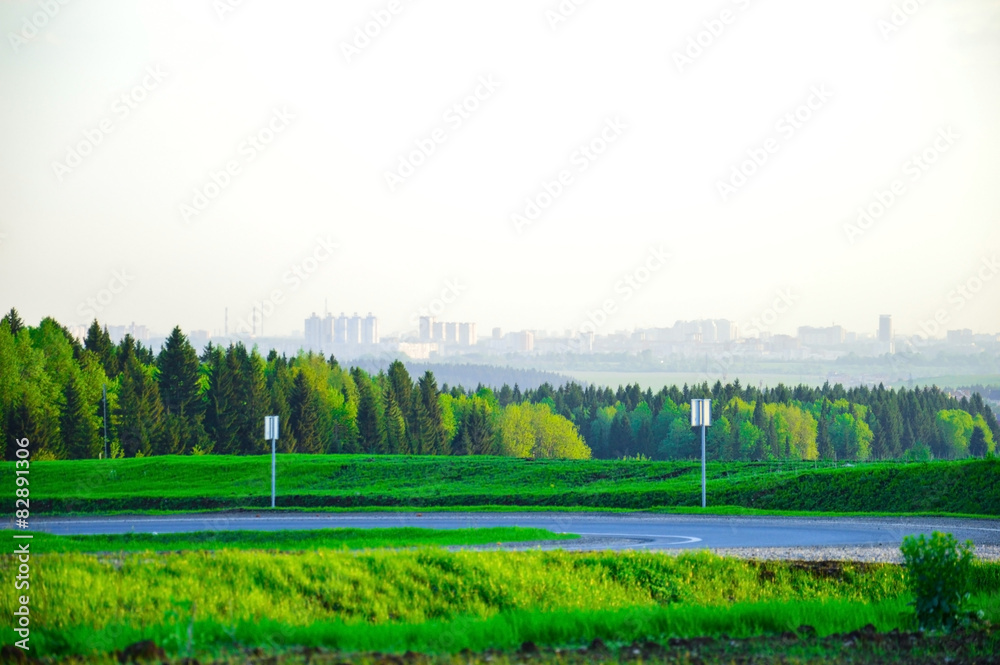 Пейзаж с видом города в дымке на горизонте