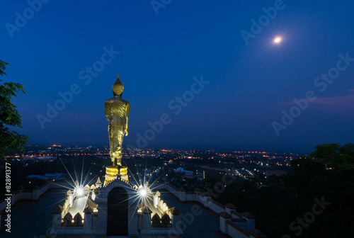 Golden Buddha statue on night background in Wat Phra That Khao N