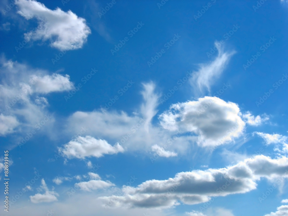 Obraz premium Blue sky background with wavy fleecy clouds