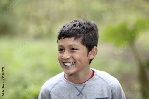 Young smiling mixed race boy in woods - shallow depth of field