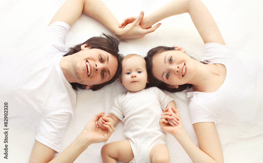 Closeup portrait of happy family together lying on the bed at ho