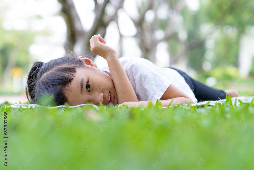 Asian kid portrait with relax pose in the green garden Asian kid portrait with relax pose in the green garden