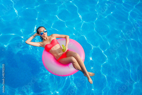 Beautiful girl in the pool on inflatable lifebuoy