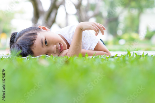 Asian kid portrait with relax pose in the green garden