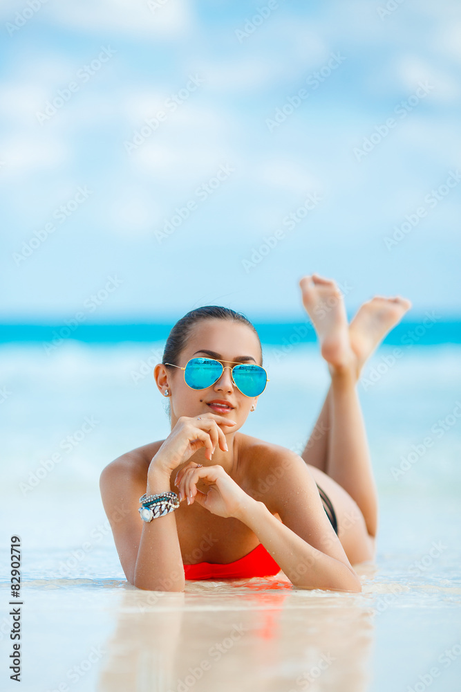 Young female enjoying sunny day on tropical beach.