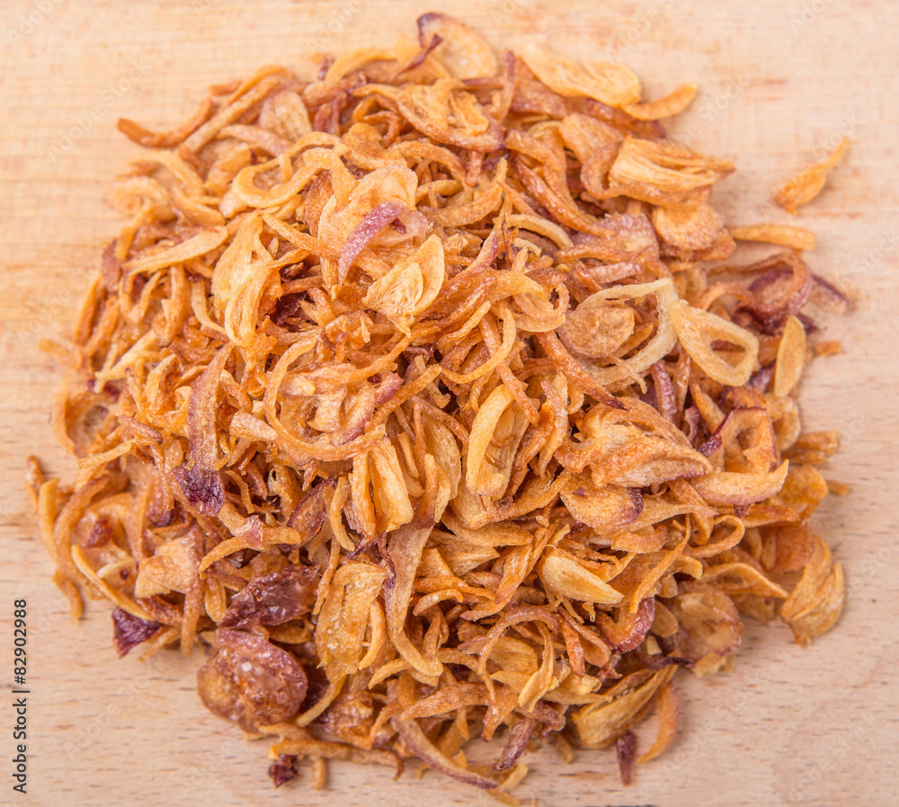 Deep fried shallots for garnishing on wooden surface