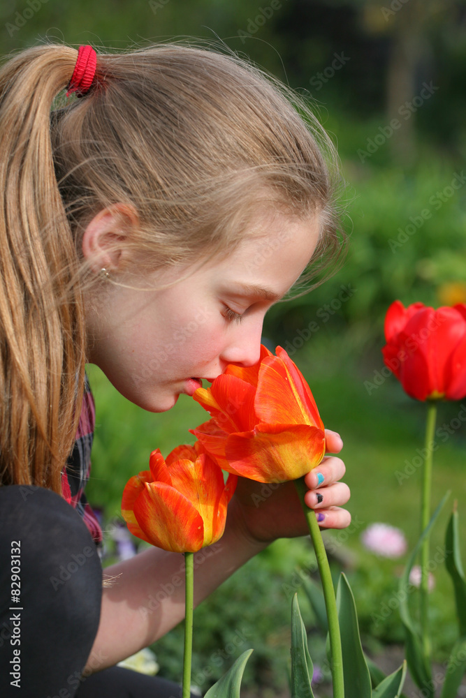 girl smelling flowers in the garden
girl smelling flowers in the garden