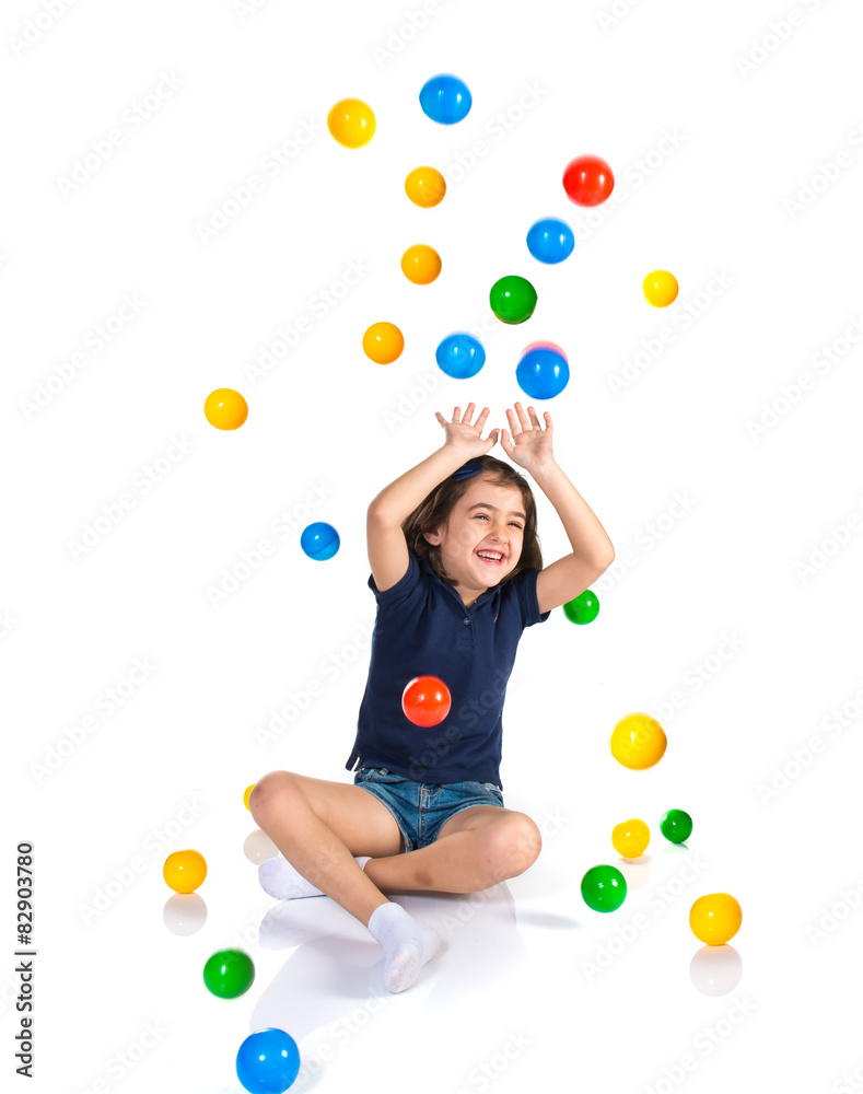 Fototapeta premium Girl playing while raining colored balls