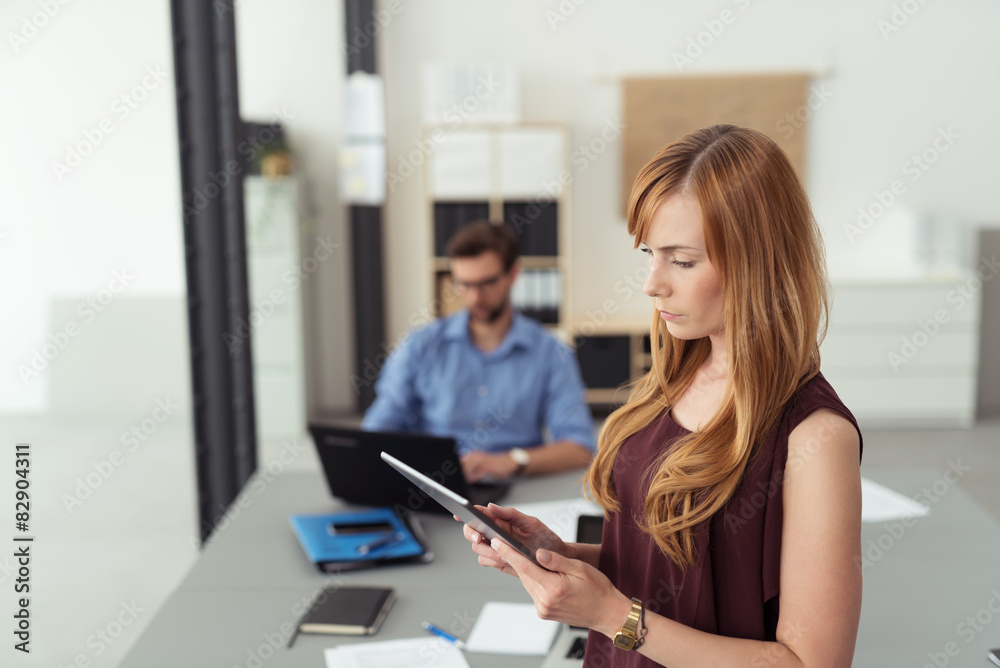 frau im büro liest am tablet-pc frau im büro liest am tablet-pc