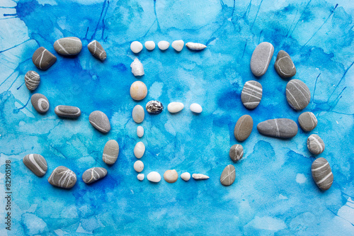 The word "sea" from stones and seashells on the turquoise waterc
