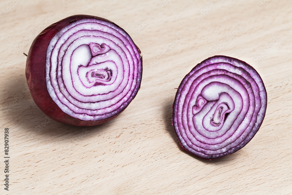 Cut of red onion on wood background.